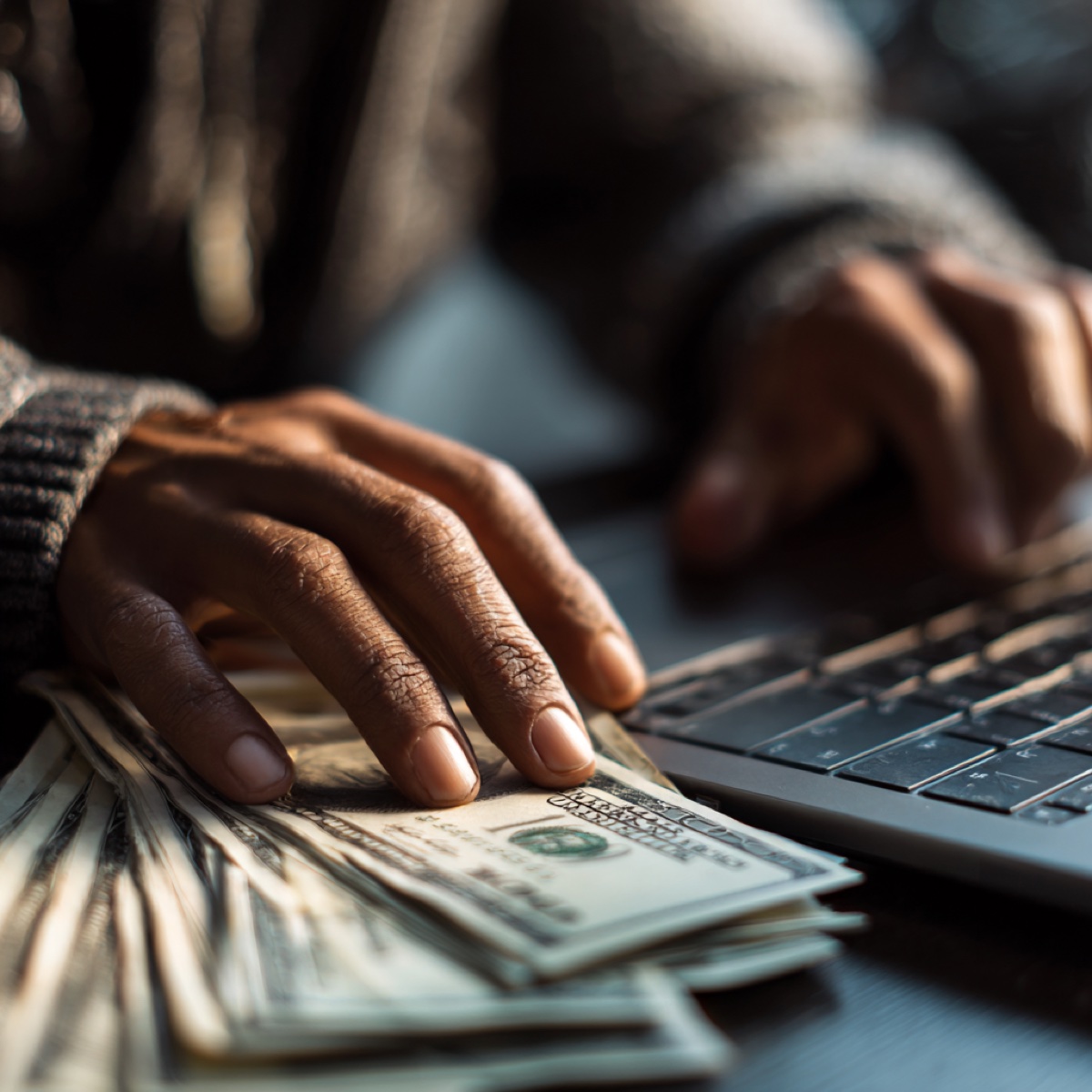 Cartel scam text messages target innocent victims - cybercriminal hands typing threatening text messages on keyboard with money demanding payments from unsuspecting victims through fear-based manipulation